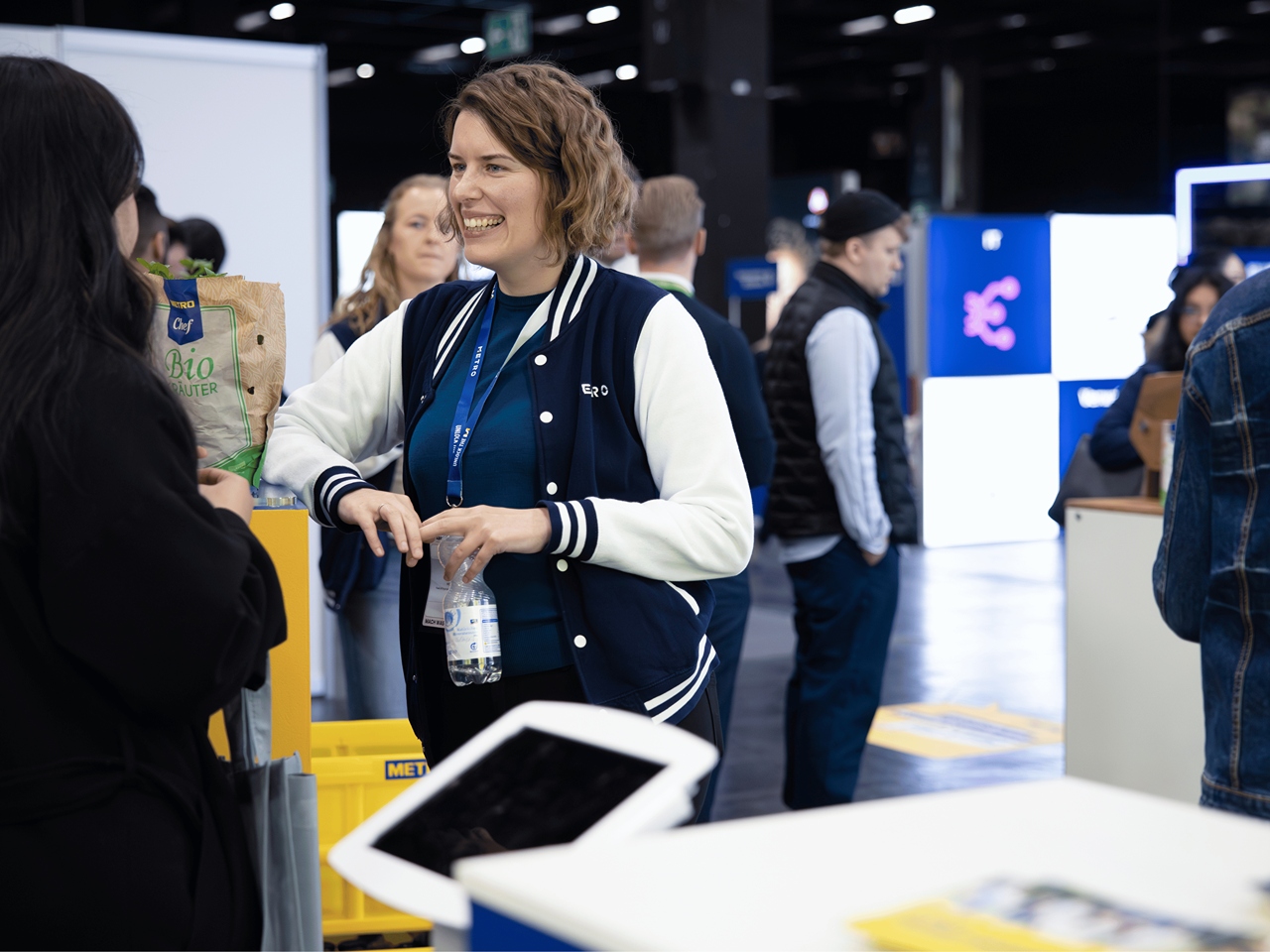 Eine lächelnde Ausstellerin im Gespräch mit einer Messebesucherin.